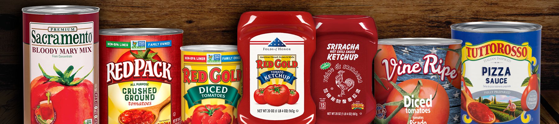 Red Gold and Tuttorosso tomato products arranged on a wooden surface, showcasing different tomato-based ingredients.
