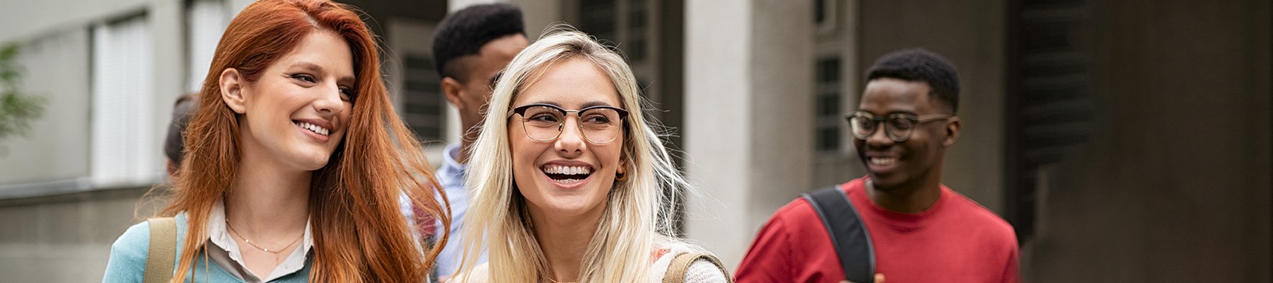 Group of happy college students walking together on campus, smiling and enjoying their day.